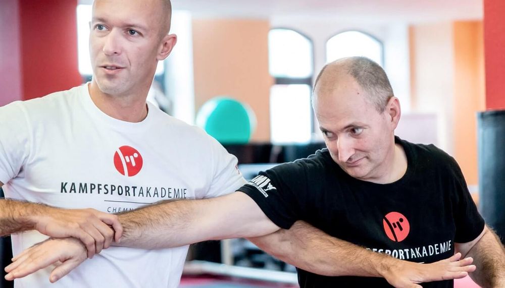 Trainer korrigiert im Krav-Maga-Training eine Technik